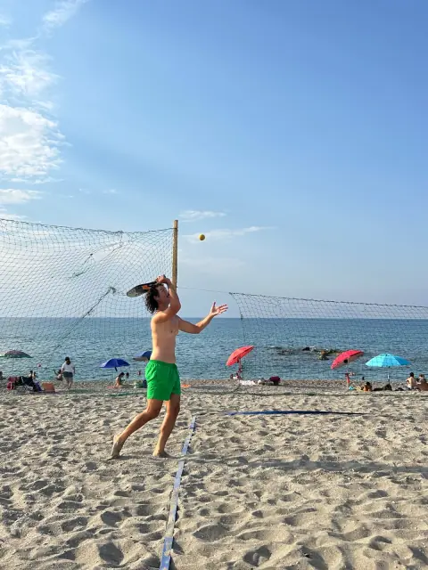 Un giocatore colpisce la palla durante il torneo di beach tennis